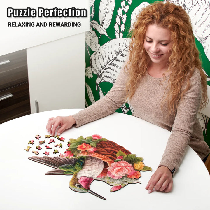 Woman assembling Glorious Hummingbird puzzle with colorful bird outline and vibrant flowers, focused