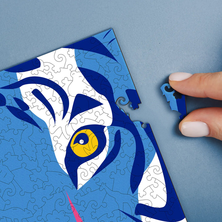 Hands assembling a difficult puzzle for adults with bold lines and rich color